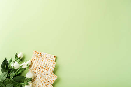 Passover celebration concept. Matzah, red kosher wine, walnut and spring beautiful rose flowers....