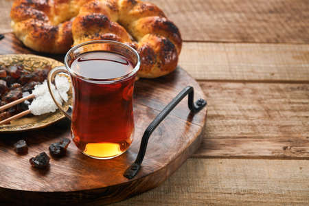 Turkish black tea. Glass cup of turkish black tea and crispy Turkish traditional bagel on old...