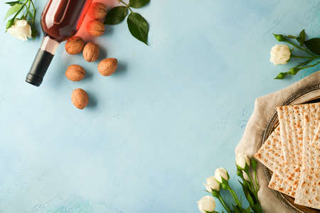 Passover celebration concept. Matzah, red kosher walnut and spring beautiful rose flowers....