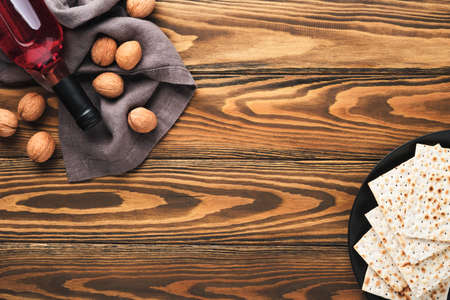 Passover celebration concept. Matzah, red kosher and walnut. Traditional ritual Jewish bread on sand...
