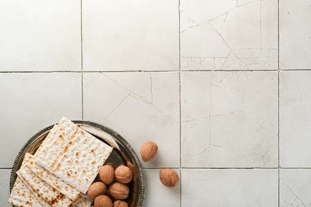 Passover celebration concept. Matzah, red kosher walnut. Traditional ritual Jewish bread on old gray...
