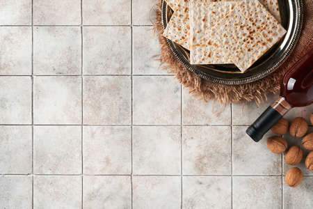 Passover celebration concept. Matzah, red kosher walnut. Traditional ritual Jewish bread on old gray...