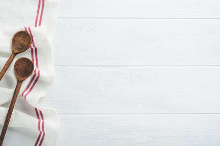 Ceramic empty white plate. Rustic vintage set of white plate, wooden spoon on light white wooden background. Vintage zero waste silverware. empty dishes. top view. Mock up.の写真素材