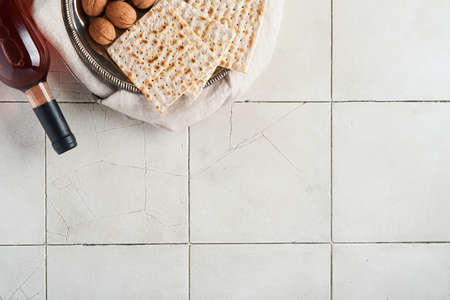 Passover celebration concept. Matzah, red kosher walnut. Traditional ritual Jewish bread on old gray...