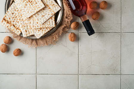 Passover celebration concept. Matzah, red kosher walnut. Traditional ritual Jewish bread on old gray...