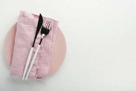 Ceramic empty pink plate. Rustic vintage set of white plate, wooden spoon on light white wooden background. Vintage zero waste silverware. empty dishes. top view. Mock up.の写真素材