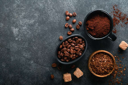 coffee bean background. Roasted Coffee concept with differents types of coffee, beans and cinnamon sticks on dark black stone background. top view. coffee concept. Mock up.の写真素材