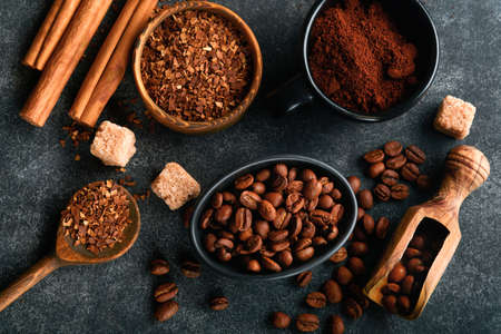 coffee bean background. Roasted Coffee concept with differents types of coffee, beans and cinnamon sticks on dark black stone background. top view. coffee concept. Mock up.の写真素材