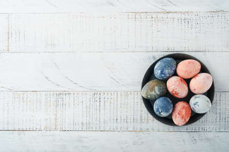 Easter eggs. Dyed Easter eggs with marble stone effect ref and blue color in rustic style on old wooden white background. Easter background. top view.の写真素材
