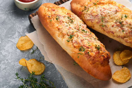 Baguette boats. Hot baked sandwich on baguette bread with ham, bacon, vegetables and cheese on...