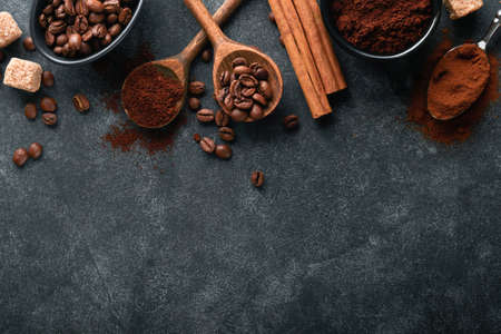coffee bean background. Roasted Coffee concept with differents types of coffee, beans and cinnamon sticks on dark black stone background. top view. coffee concept. Mock up.の写真素材