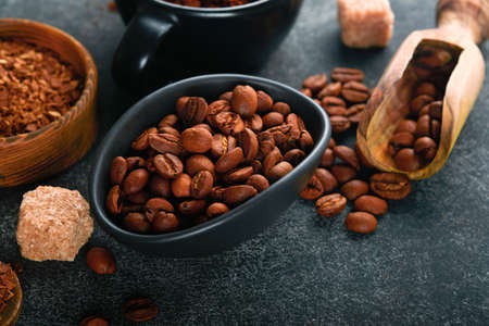 coffee bean background. Roasted Coffee concept with differents types of coffee, beans and cinnamon sticks on dark black stone background. top view. coffee concept. Mock up.の写真素材