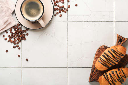Coffee and croissants. Espresso coffee and croissant with chocolate on old cracked tile table. Perfect Croissant Breakfast in the morning. rustic style. top view. Mock up.の写真素材