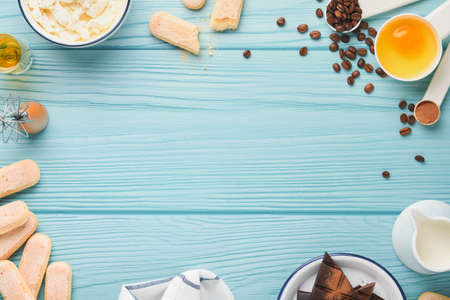 Tiramisu dessert. Ingredients for making dessert tiramisu. Cooking Italian food dessert Tiramisu with all necessary ingredients cocoa, coffee, mascarpone cheese on turquoise wooden background Top viewの写真素材