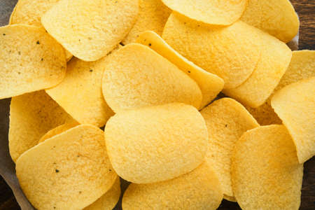 Potato corrugated chips. fast food. Crispy potato chips ceramic black bowl with sour cream sauce and...