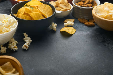 unhealthy foods. Snacks. All classic potato snacks with peanuts, popcorn and onion rings and salted...