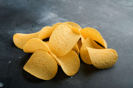 Potato corrugated chips. fast food. Crispy potato chips ceramic black bowl with sour cream sauce and...