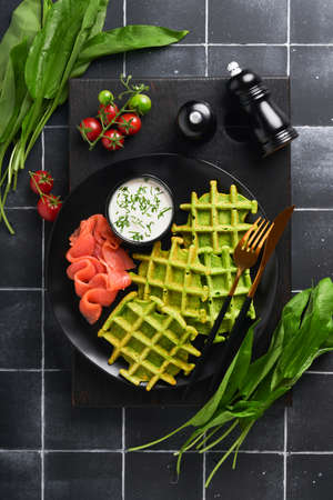 Green Belgian waffles. Spinach or wild garlic or pesto waffles with red salmon and cream sauce on...