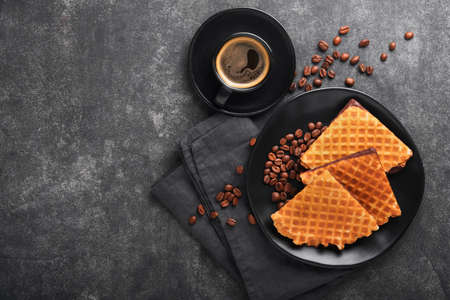 Coffee and dutch waffles. Espresso coffee and dutch waffles or syrupwaffles cookies with chocolate on old on black concrete table. Perfect syrupwaffles cookies for Breakfast . top view. Mock up.の写真素材