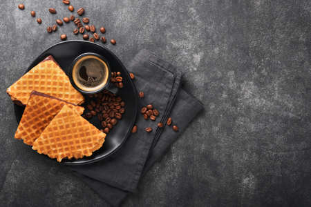 Coffee and dutch waffles. Espresso coffee and dutch waffles or syrupwaffles cookies with chocolate on old on black concrete table. Perfect syrupwaffles cookies for Breakfast . top view. Mock up.の写真素材