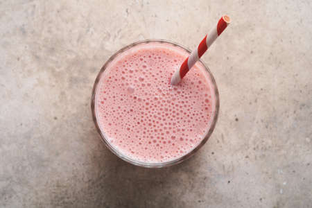 Strawberry smoothies. Vegan smoothie or milkshake from strawberry, banana and mint on white wooden table background. Clean eating, alkaline diet. top view. Mock up.の写真素材