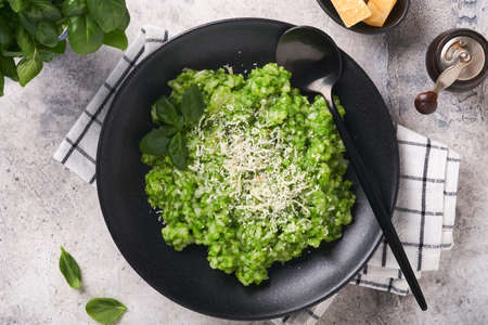 Italian risotto. Delicious risotto in white plate with pesto sauce or wild garlic pesto, basil,...