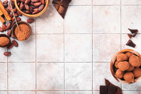 Chocolate truffles with cocoa powder in wooden dish on old cracked tile table background. Tasty sweet chocolate truffles candies. Valentine's Day and Mother's Day concept with copy space. top view.の写真素材