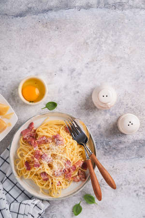 Carbonara pasta. Spaghetti with pancetta, egg, parmesan cheese and cream sauce on old gray concrete table background. Traditional italian cuisine and dish. Pasta alla carbonara. top view.の写真素材