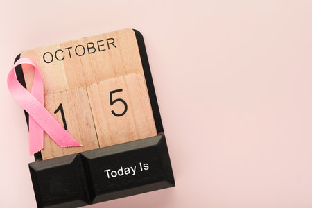 Pink Breast Cancer Awareness Ribbon. Wooden calendar with pink ribbons on backgrounds. Breast cancer awareness and October Pink day, world cancer day. top view. Mock up.の写真素材