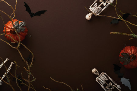 Halloween background. Flock of black bats, spider, pumpkin, skeleton and leaves for Halloween. Black paper bat silhouettes on brown or dark background. autumn decoration. Halloween concept. top view.の写真素材