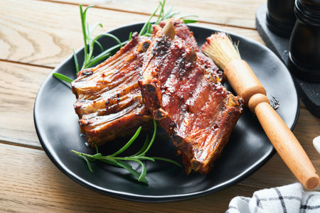 Grilled and smoked pork ribs with barbeque sauce on an old vintage wooden cutting board on old wooden table background. Tasty snack to beer. american food concept. top view.の写真素材
