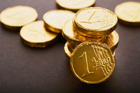 chocolate coin. Backgrounds of chocolate Euro coin money on brown background. Euro coins stacked on...