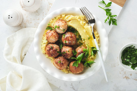 Swedish meatballs in cream sauce, potatoes and lingonberry sauce in bowl on slate, stone or concrete backgrounds. swedish food. Delicious creamy mashed potatoes. top view.の写真素材