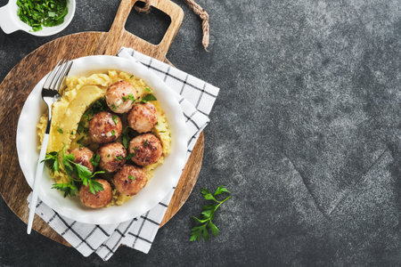 Swedish meatballs in cream sauce, potatoes and lingonberry sauce in bowl on slate, stone or concrete backgrounds. swedish food. Delicious creamy mashed potatoes. top view.の写真素材