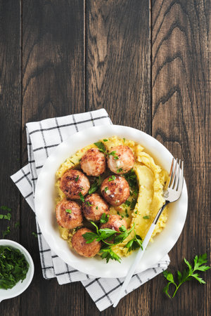Swedish meatballs in cream sauce, potatoes and lingonberry sauce in bowl on old wooden rustic backgrounds. Swedish food. Delicious creamy mashed potatoes. top view.の写真素材