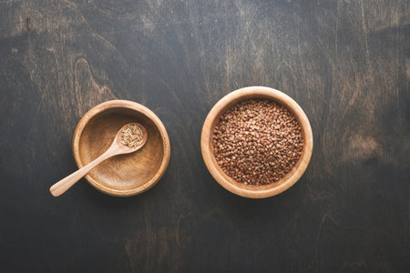 world food crisis concept. Empty and full old plate with buckwheat on a dark gloomy background....