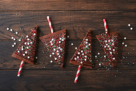 Chocolate brownies Christmas tree with chocolate icing and festive sprinkles on wooden table. Christmas food ideas sweet homemade Christmas holidays pastry concept. Holiday cooking concept. Top view.の写真素材