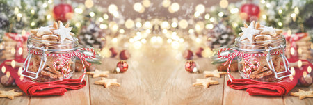 Christmas shortbread cookies or gingerbread stars with red ribbon, festive decoration, fir tree,balls and light garland. Traditional german cookies. Christmas celebration traditions family culinary.の写真素材