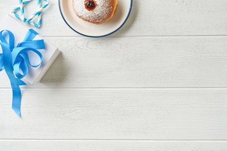 Happy Hanukkah. Hanukkah sweet doughnuts, gift boxes, white candles and chocolate coins on white wooden background. Image and concept of jewish holiday Hanukkahの写真素材
