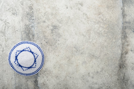 Passover celebration concept. Matzah, red kosher and walnut. Traditional ritual Jewish bread matzah, kippah and tallit on old concrete background. Passover food. Pesach Jewish holiday.の写真素材