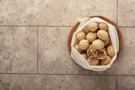 Passover celebration concept. Organic walnuts in eco bags on old gray cracked tile countertop table...
