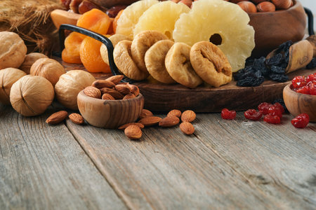 Tu Bishvat celebration concept. Mix of dry fruits and nuts almonds, hazelnuts, walnuts, apricots, prunes, cherries, raisins, dates, apples, figs over wooden table. Jewish holiday, new year of trees.の写真素材