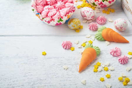 Sweet Easter concept. Sweet Easter kids holiday assortment marshmallows rabbit, chocolates easter eggs, candies, bunny, snacks on white wooden background. Flat lay Easter decoration idea. Mock up.の写真素材