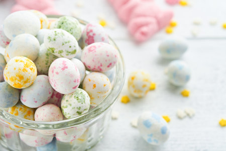 Sweet Easter concept. Sweet Easter kids holiday assortment marshmallows rabbit, chocolates easter eggs, candies, bunny, snacks on white wooden background. Flat lay Easter decoration idea. Mock up.の写真素材