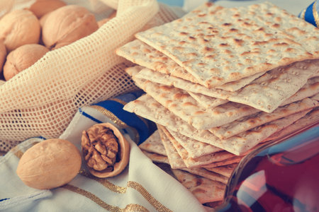 Passover celebration concept. Matzah, red kosher and walnut. Traditional ritual Jewish bread matzah,...