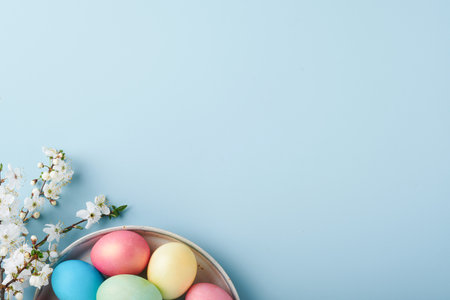Happy Easter. Dyed Easter eggs on rustic table with cherry blossom tree branch on blue background. Easter holiday card background with copy space. top view.の写真素材