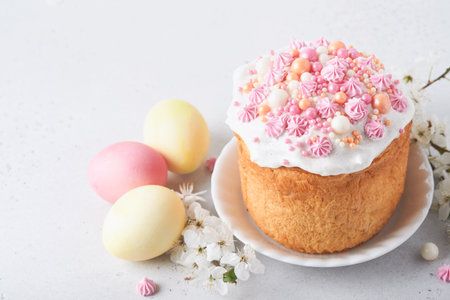 Traditional Easter sweet bread or cakes with white icing and sugar decor, colored eggs and cherry...