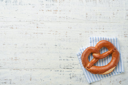 Oktoberfest concept card. Traditional Bavarian pretzels with beer bottle mug on old white rustic...