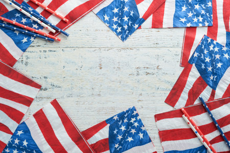 4th of July background. US flag paper napkin and picnic cocktail straws on old white table background. Happy Labor, Independence, Presidents Day. Happy picnic concept. american flag colors. Mock up.の写真素材