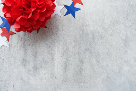 4th of July background. USA paper fans, Red, blue, white stars and confetti on gray old concrete...